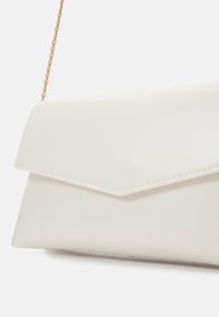 Vitt kuvertfodral i fejkläder med klaffstängning och guldkedjas rem. Har rena linjer, slät textur och kontrasterande sömmar.