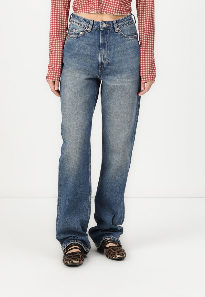 High-waisted blue denim jeans with a straight leg, featuring a light wash, subtle fading, and a classic five-pocket design.
