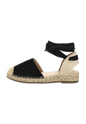 Sandalia alpargata negra con suela de yute trenzado, puntera cerrada, talón abierto y lazo negro para atar en el tobillo.
