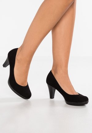 Chaussures à talons hauts en daim noir avec un bout arrondi et une plateforme légèrement surélevée, présentant un talon texturé et un empeigne lisse.