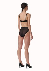 Zwarte mesh high-waisted onderbroek met verstelbare bandjes, gekenmerkt door een zachte textuur en een minimalistisch ontwerp. Achteraan is er een naadloze afwerking te zien.