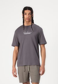 Gray short-sleeve t-shirt featuring a white "Sakura Blossom" graphic on the front. The material appears soft with a relaxed fit.