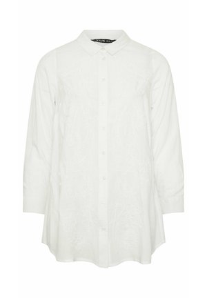 Hvid skjorte med lange ærmer, knapper foran, krave og subtil blomsterbroderi på forsiden, let udvidet kant og knappede manchetter.