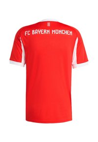 Maillot de sport rouge avec des manches courtes blanches, "FC Bayern München" imprimé en blanc au dos, avec des accents blancs contrastants sur le col.
