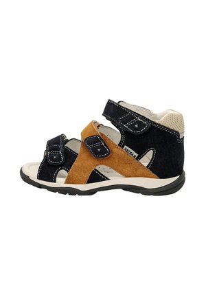 Sandali in suede neri e tan con cinturini in velcro, design open toe, suola bianca e supporto imbottito alla caviglia. Adatti per un abbigliamento informale.