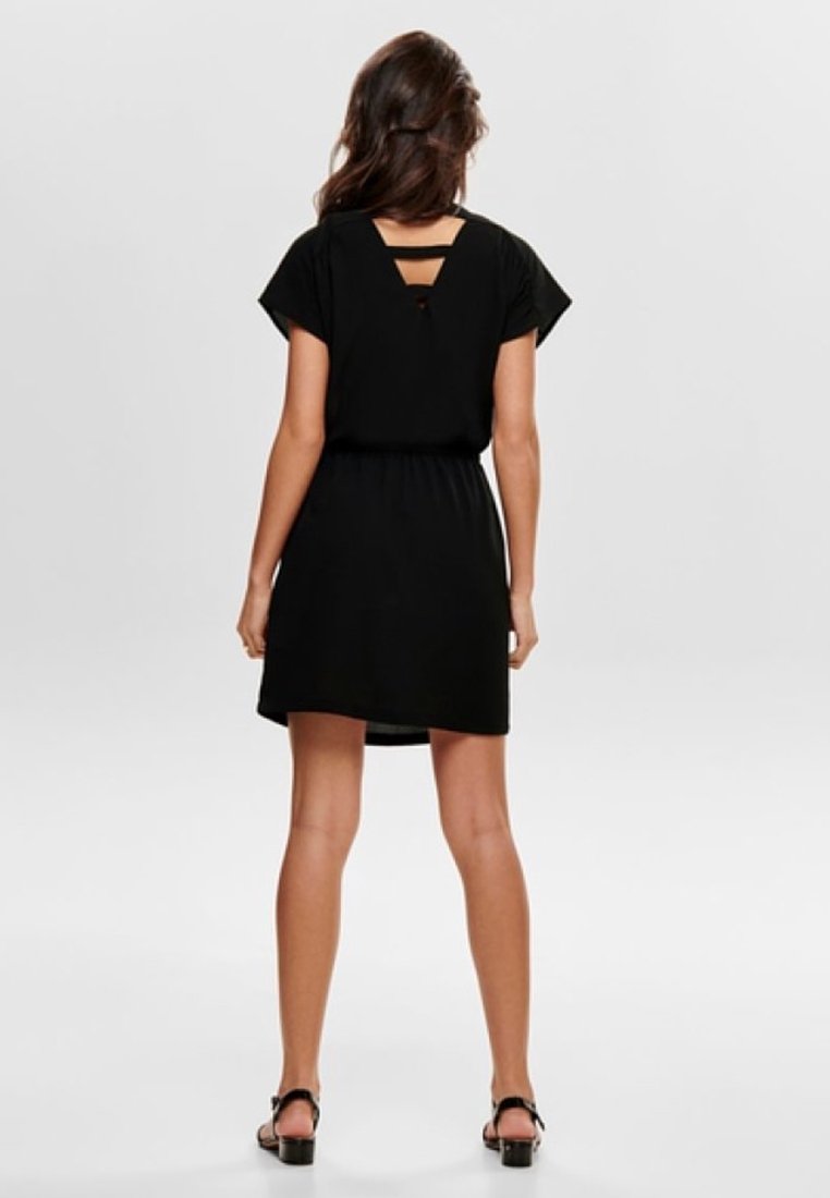 Schwarzes Kurzarmkleid mit tailliertem Schnitt, das eine ausgeschnittene Rückenpartie und einen sanften Stoff aufweist. Der Saum endet oberhalb des Oberschenkels.