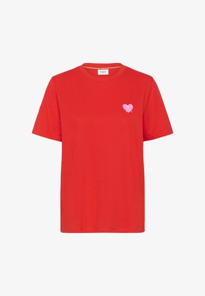 Červené tričko s krátkými rukávy a kulatým výstřihem, s malým růžovým srdcem a mašlí na levé straně hrudi, značka Saint na límci.