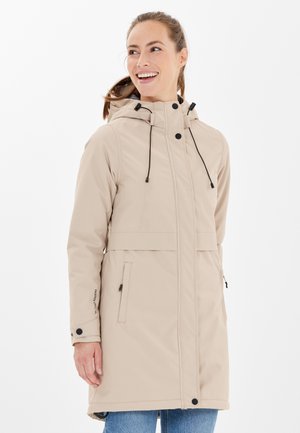 Beige waterdichte jas met capuchon, verstelbare trekkoorden, voorzakken en een ritssluiting. Gladde textuur en middellange ontwerp.