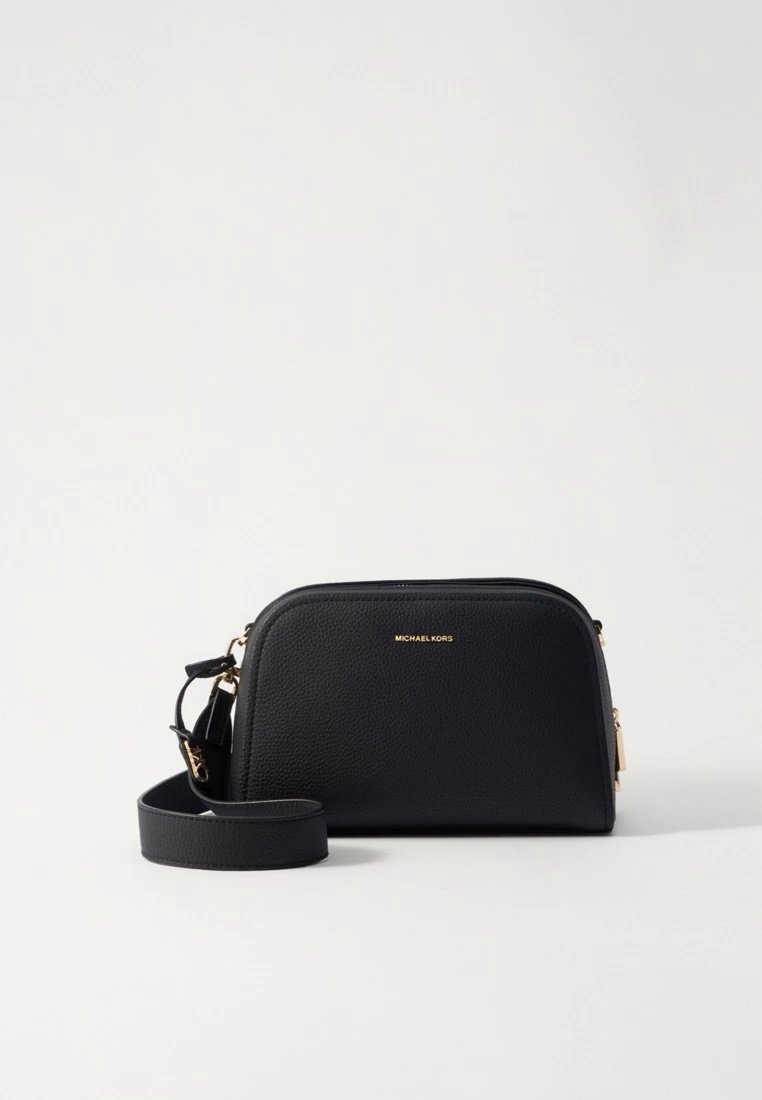 Sac bandoulière en cuir noir avec ferrures dorées, forme arrondie, fermeture éclair et bandoulière réglable. Présente un logo embossé à l'avant.