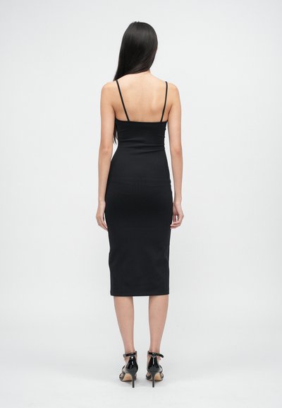 Rochie midi ajustată de culoare neagră, cu bretele subțiri, o siluetă dreaptă și o textură netedă. Purtați cu sandale cu toc înalt cu curele negre.