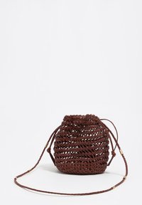 Bolso tipo cubo pequeño de cuero marrón tejido con cierre de cordón y correa larga trenzada con detalles dorados, sobre fondo blanco.