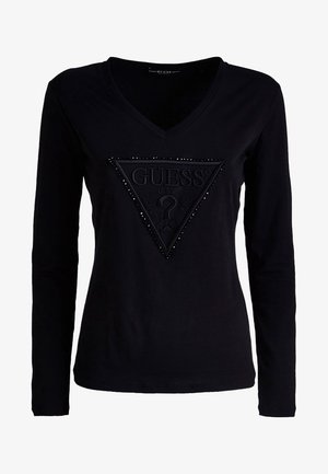 Musta pitkähihaine t-paita V-aukkolla, jossa on teksturoitu kolmion logo niiteillä. Valmistettu pehmeästä kankaasta, yksinkertainen muotoilu.