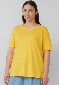 Gelbes Baumwoll-T-Shirt mit kurzen Ärmeln und rundem Ausschnitt. Der Stoff wirkt glatt und leicht, mit einer lässigen Passform.