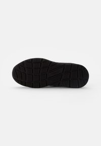 Suola di scarpa in gomma nera con un motivo di battistrada texturizzato per una migliore aderenza, con il marchio "superfit" impresso sul lato.