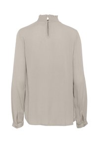 Light beige long-sleeve blouse, fabric with a soft texture. Features a ruffled neckline, back keyhole opening, and buttoned cuffs.