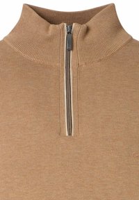 Maglione beige lavorato a maglia con colletto a coste alto e una mezza zip centrale in argento.