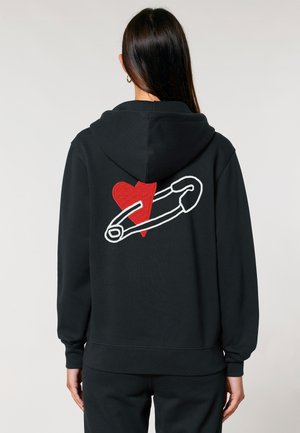 Black hoodie featuring a large red heart and a white outline of a safety pin embroidered on the back. Soft fabric with a relaxed fit.