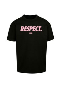 T-shirt noir en coton, arborant le mot "RESPECT." en lettres roses en gras sur le devant, avec des manches courtes et un col rond.
