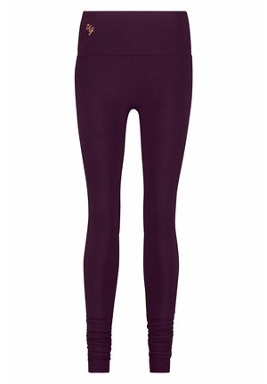 Lila Leggings mit hohem Bund, gefertigt aus dehnbarem Material. Verfügt über ein dezentes, oranges Logo am Bund. Glatte Textur, knöchellange Ausführung.