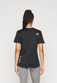 Μαύρο αθλητικό t-shirt με κοντά μανίκια, στρογγυλή λαιμόκοψη και μικρό λογότυπο στο πάνω μέρος της πλάτης, με ίσιο τελείωμα και μαλακό ύφασμα.