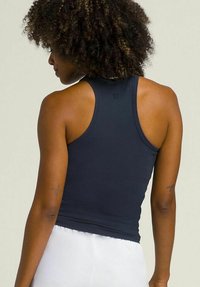 Camiseta sin mangas de color azul marino oscuro con un diseño ajustado y escote redondo, hecha de una tela suave, con un logo en la parte posterior.
