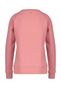 Różowy sweatshirt z długimi rękawami raglanowymi, ściągaczami przy rękawach i u dołu. Gładka tekstura, bez widocznych wzorów, z małą metką logo z tyłu.