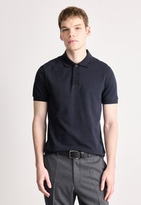 Ναυτικό μπλε πόλο μπλούζα από ελαφρύ ύφασμα με κοντά μανίκια, τρεις κουμπότρυπες και διακριτό λογότυπο της μάρκας στο στήθος.
