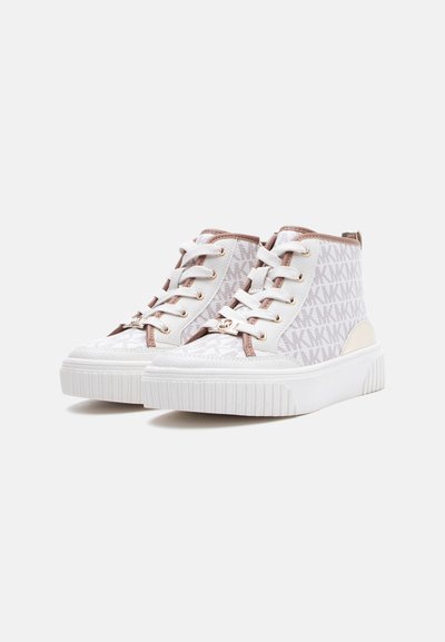 Λευκά και μπεζ ψηλά αθλητικά παπούτσια με μοτίβο λογότυπου "MK", παχιά λευκή σόλα, λευκά κορδόνια και χρυσά στριφώματα, εμφανιζόμενα από πλάγια γωνία.