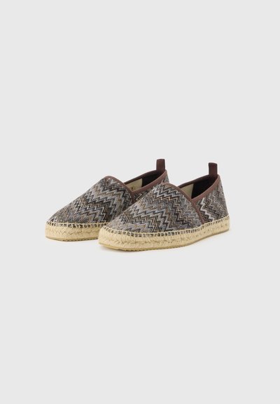 Espadrilles à enfiler avec tissu brun à motif zigzag et semelles en jute tressé beige sur fond clair.