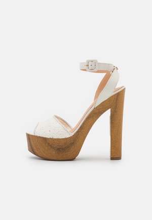 Weiße Plattform-Sandalen mit einer strukturierten Spitzenfront, einem Knöchelriemen und einem Holzblockabsatz, ausgestattet mit einer glatten Oberfläche und einer Schnallendetail.