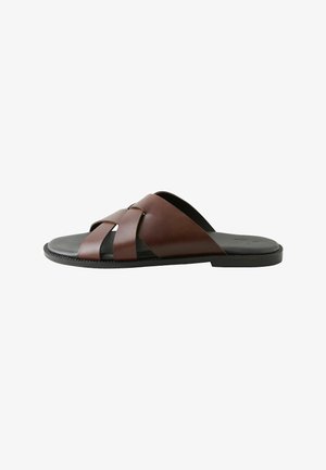 Pánska hnedá kožená sandála na šmyk s prekríženými remienkami a čiernou podrážkou, zobrazená v bočnom profile na bielom pozadí.