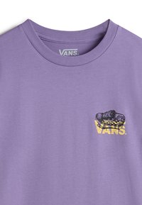 Fialové tričko z bavlny s malou grafikou boty a slovem "VANS" v žluté barvě blízko levé strany. Kulatý výstřih, krátké rukávy.