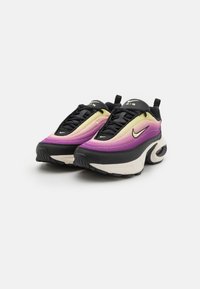 Nike Air sneakers feature an upper in gradient purple and yellow, black detailing, and a textured black sole with visible air cushioning.