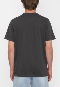 Camiseta de algodón gris oscuro con mangas cortas, escote redondo y un corte relajado. Textura suave sin patrones ni gráficos.