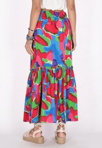 Fust�ă maxi colorată, cu un model vibrat, având o margine ondulată, talie elastică și un design vibrat în tonuri de albastru, verde, roz și violet.