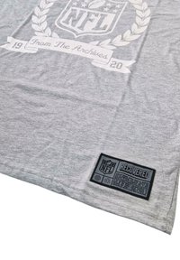 Gray t-shirt featuring a large white NFL logo and text "From The Archives 19-20." Includes a black "RECOVERED" label on the hem.