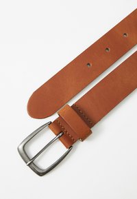 Brown leather belt with a silver metal buckle. Features a smooth texture, six punched holes, and a leather keeper near the buckle.