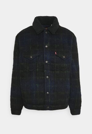 Ciemna kraciasta wełniana kurtka z czarnym kołnierzem sherpa, zapinana na zatrzaski z przodu, z dwoma kieszeniami na klapę na piersi, zapinanymi na guziki.