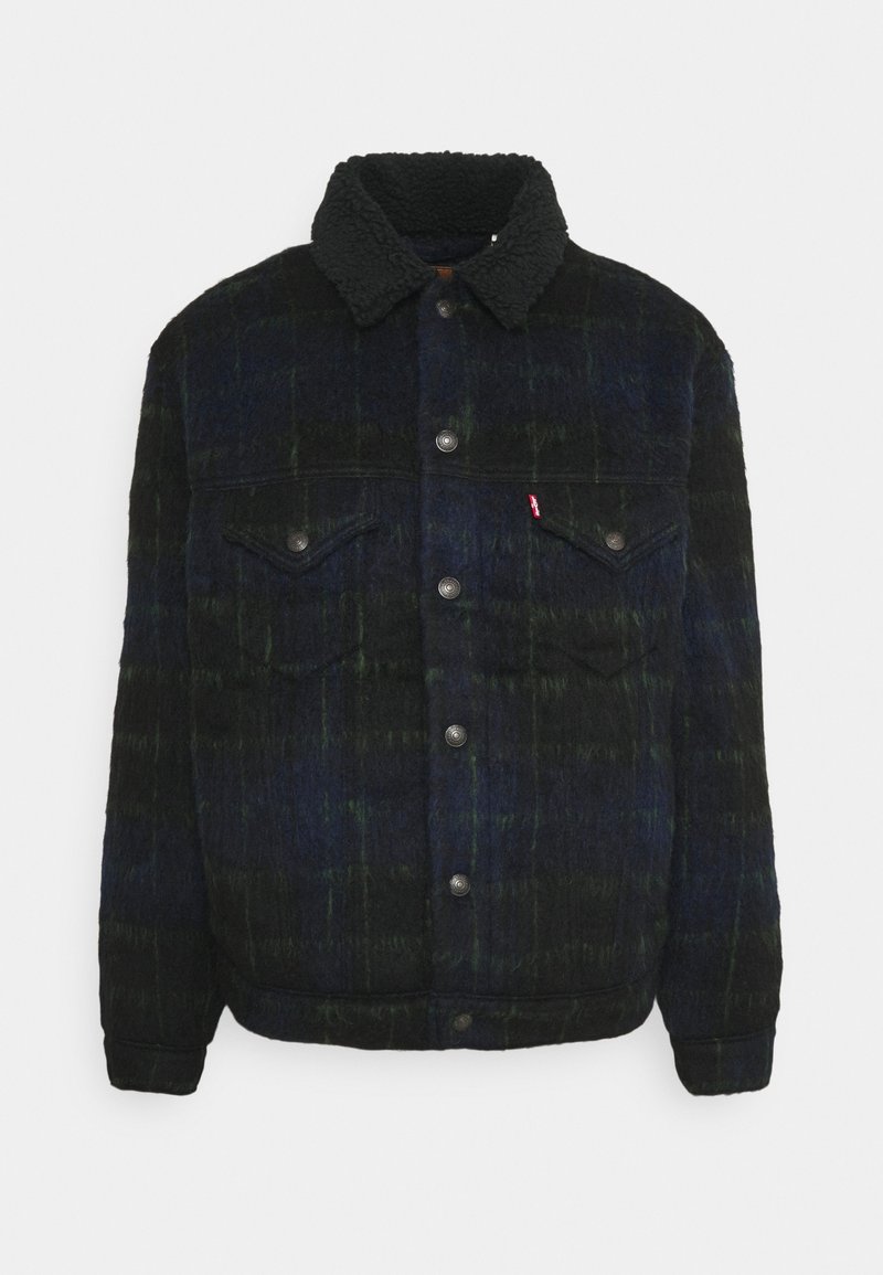Veste en laine à carreaux sombre avec col en sherpa noir, fermeture à boutons pression sur le devant, et deux poches poitrine à rabat avec boutons.