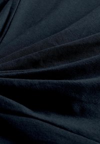 Must must on sile ja sujuva tekstuuriga, sügavate kortsudega ja kergelt läikiv. Materjal tundub kerge ja pehme, esitades dünaamilise lange.