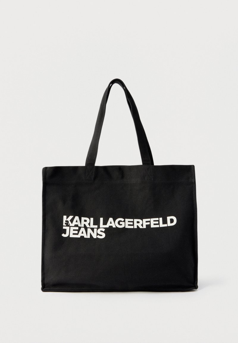 Črna torba za nošenje z dvema ročajema, na sprednji strani je na sredini bel napis "KARL LAGERFELD JEANS".