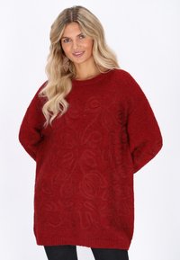 Roter Strickpullover mit einem strukturierten Blumenmuster, lässiger Passform, Rundhalsausschnitt und langen Ärmeln. Weiches Garn mit Rippensaum.