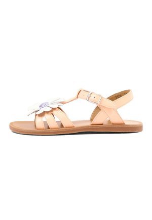 Kindersandalen in beige met enkelriem, witte bloemversiering en platte zool, zijaanzicht.