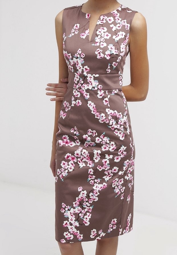 Brun satin kjole med en tætsiddende silhuet, blomster mønster i pink og hvid, ærmeløs design og en nøglehulsudskæring.