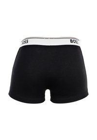Caleçon boxer noir en coton ; il présente une ceinture blanche avec le logo « BOSS », une texture lisse et une coupe ajustée.