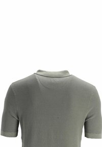 Polo texturé vert olive à manches courtes, présenté de dos, avec un col souple et des manches retroussées.
