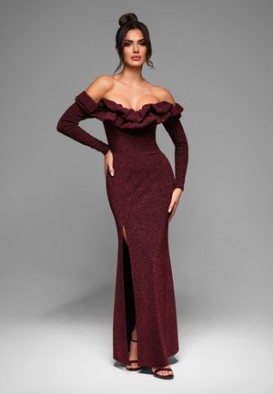 Robe bordeaux décolletée avec un col volanté, des manches longues, un corsage ajusté et une fente sur le côté ; tissu texturé avec un éclat subtil.