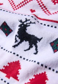 Design di renne nere su tessuto a maglia bianco, con motivi natalizi rossi e verdi, tra cui cuori e rombi, con una texture morbida.