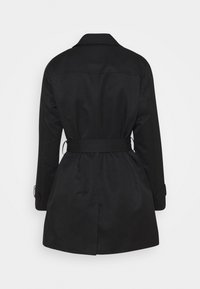 Gabardina negra de longitud a la rodilla con cinturón, mangas largas, cuello y abertura trasera, vista desde la parte posterior sobre un fondo blanco.