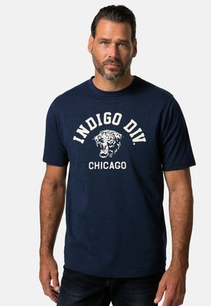 Marinblå t-shirt med kort ärm i mjukt tyg. Har vit text "INDIGO DIY CHICAGO" och en tiger grafik över bröstet.